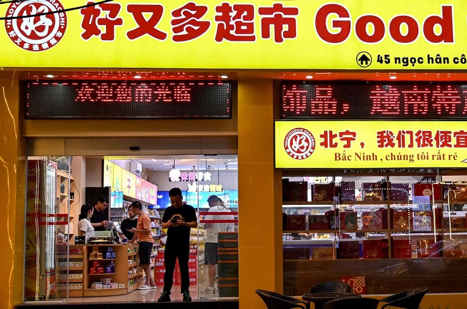 This photo taken on 22 April 2024 shows customers standing inside a convenience store in the Chinatown district of Bac Ninh province. (Nhac Nguyen/AFP)