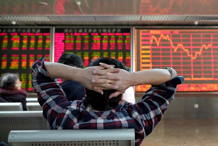 An investor looks at a stock quotation board at a brokerage office in Beijing, China, 3 January 2020. (Jason Lee/File Photo/Reuters)