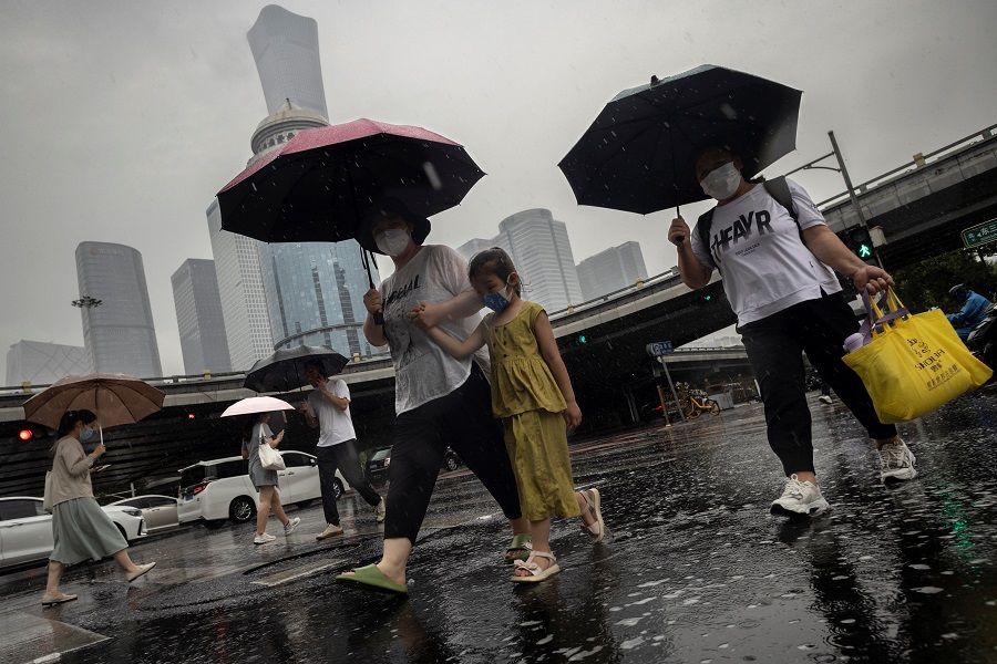 People walk in the central business district, in Beijing, China, on 12 July 2023. (Thomas Peter/Reuters)