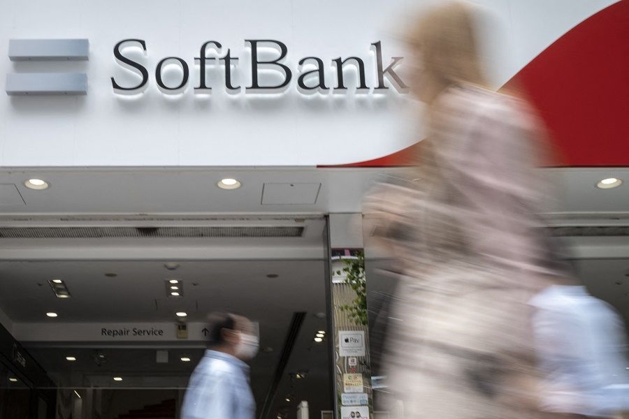 Pedestrians walk past a SoftBank mobile shop in Tokyo, Japan, on 12 May 2022. (Charly Triballeau/AFP)
