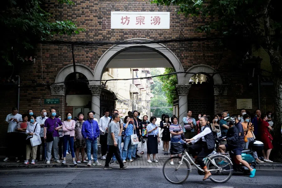 Parents wait for students behind a police line during the annual national college entrance exam, or "gaokao", at a high school in Shanghai, China, on 7 June 2023.