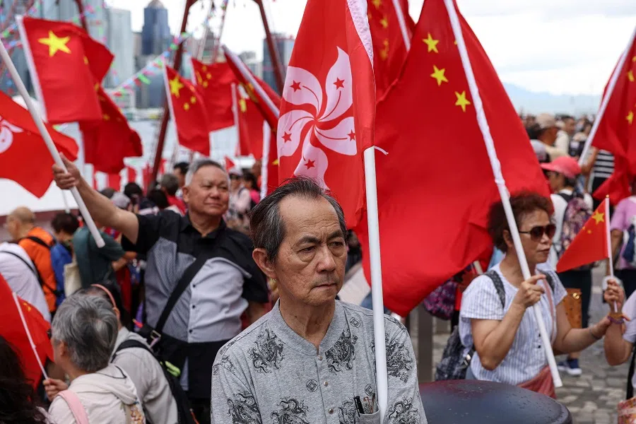 Pro-China supporters hold Hong Kong and Chinese flags at an event celebrating the 28th anniversary of the former British colony’s handover to Chinese rule, in Hong Kong, China, on 1 July 2025. (Tyrone Siu/Reuters)