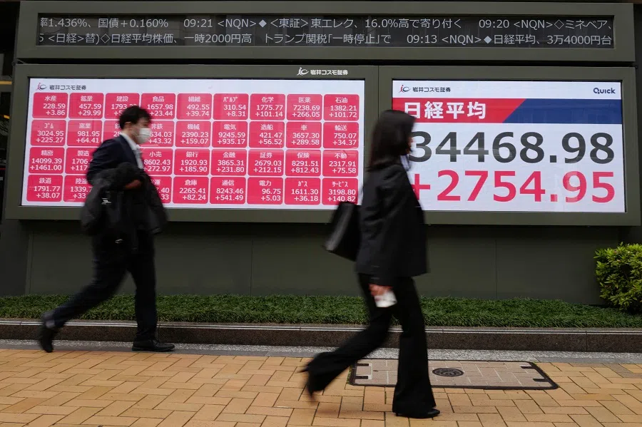 People walk past an electronic board showing the numbers of the Nikkei Stock Average on the Tokyo Stock Exchange in Tokyo, Japan, on 10 April 2025. (Kazuhiro Nogi/AFP)