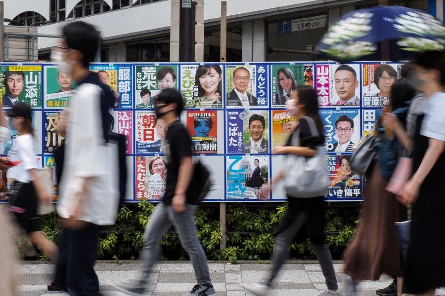 People walk past campaign posters for Japan's upper house elections in Tokyo on 10 July 2022. (Toshifumi Kitamura/AFP)