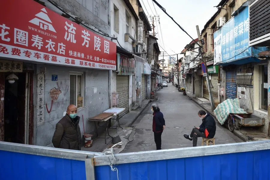 People standing near a barrier on a street in Wuhan. Questions have been raised about the effectiveness of the lockdown in Wuhan. (AFP)