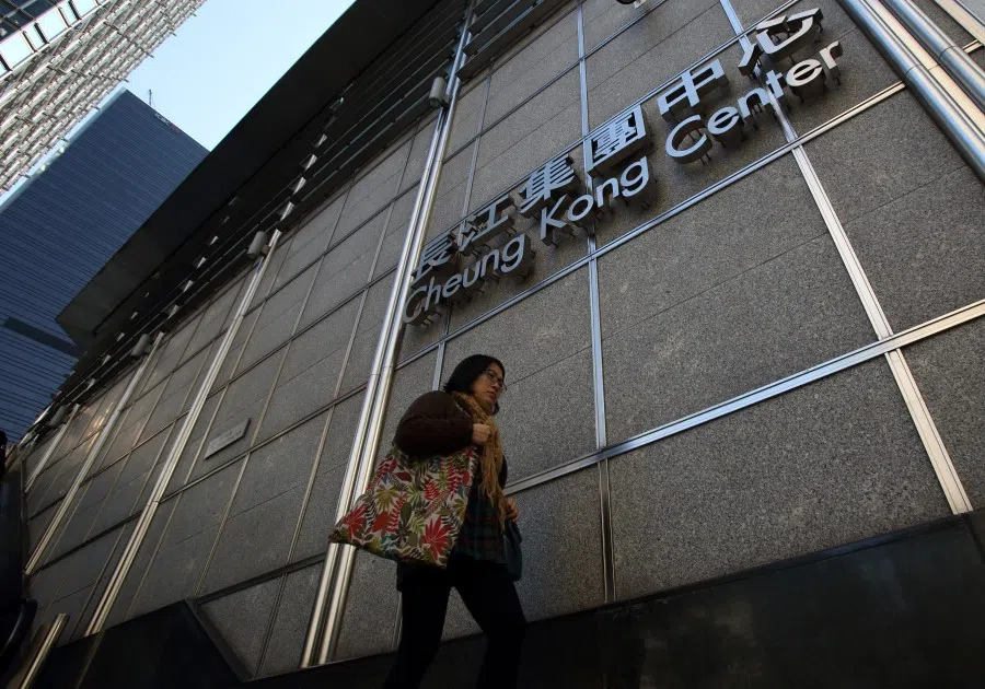 A pedestrian walks past signage for the Cheung Kong Center building in Hong Kong, China, on 9 January 2015. Cheung Kong Holdings Ltd. offered US$24 billion in stock to buy out unit Hutchison Whampoa Ltd. and will spin off its property assets in the biggest reorganisation of Hong Kong billionaire Li Ka-shing's corporate empire. (Tomohiro Ohsumi/Bloomberg)