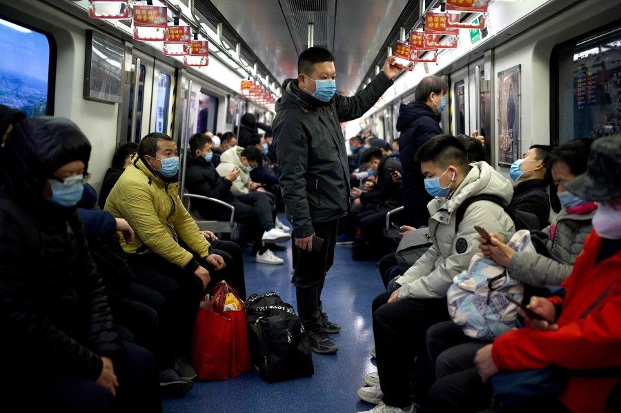 Passengers wearing face masks ride the subway in Beijing on 3 March 2021. (Noel Celis/AFP)