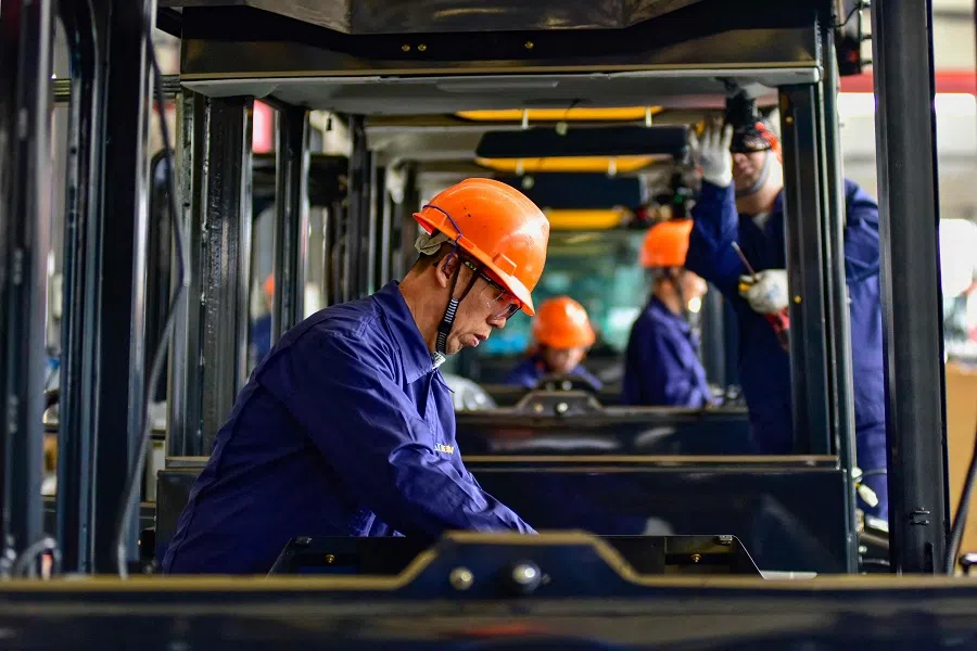 Workers build cabs for excavators at a factory in Qingzhou, in China’s eastern Shandong province on 31 October 2024. (AFP)