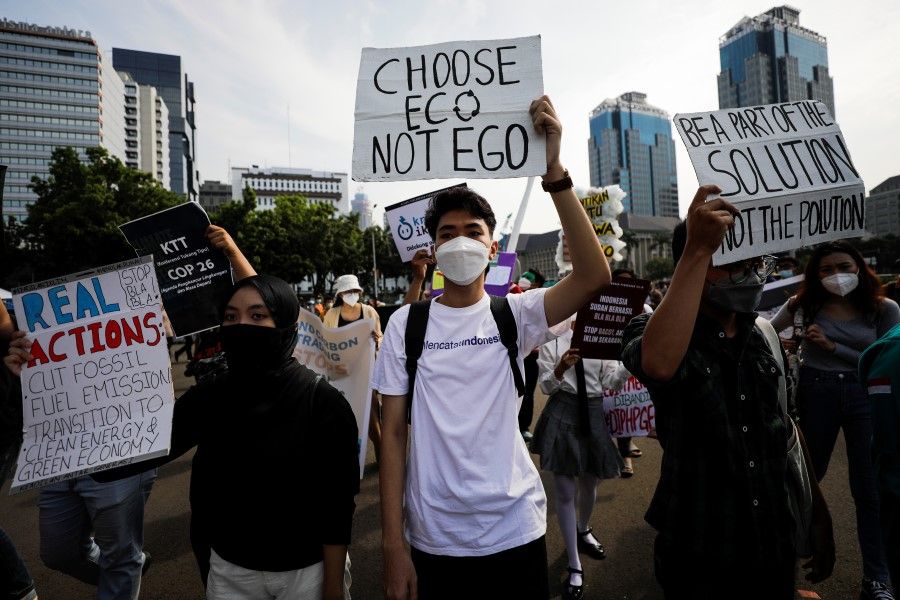 Activists carrying placards take part in a rally asking for climate justice and protest against Indonesian President Joko Widodo's statement at the UN Climate Change Conference (COP26), in Jakarta, Indonesia, 5 November 2021. (Willy Kurniawan/Reuters)