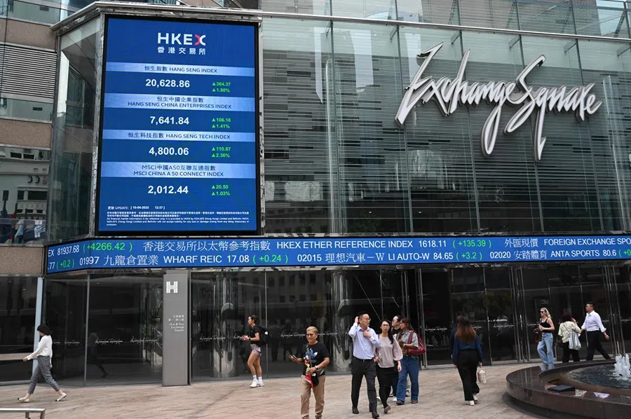 People pass an electronic sign showing the price of the Hang Seng Index at Exchange Square in Hong Kong on 10 April 2025. (Peter Parks/AFP)
