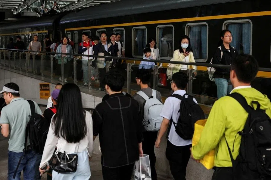 People walk on a platform after disembarking from a train at Shanghai South Railway Station in Shanghai, China, on 4 May 2025.