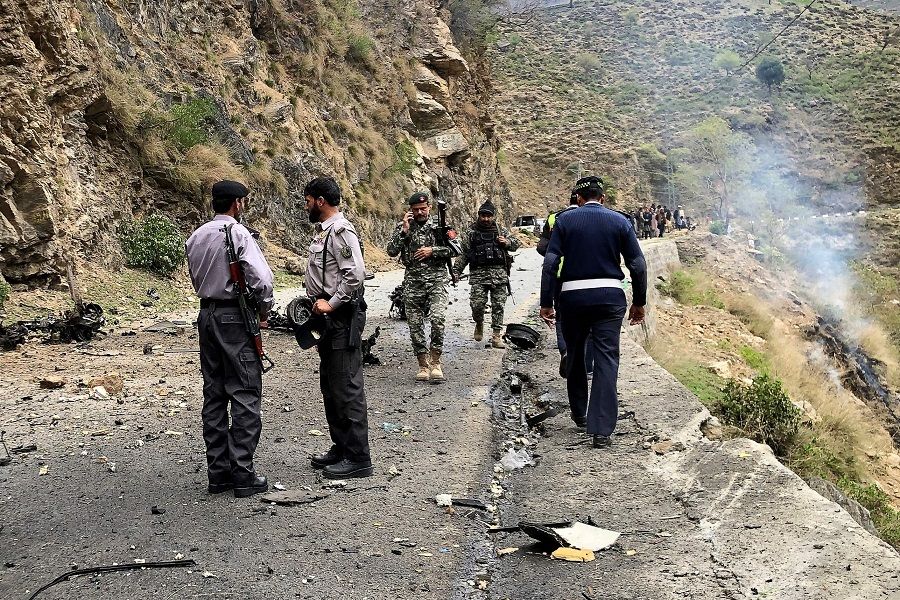 Security personnel inspect the site of a suicide attack near Besham city in the Shangla district of Khyber Pakhtunkhwa province, Pakistan, on 26 March 2024. (AFP)