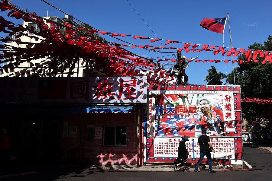 People walk past a restaurant decorated with Taiwanese flags in Taoyuan, Taiwan, 5 October 2022. (Ann Wang/Reuters)