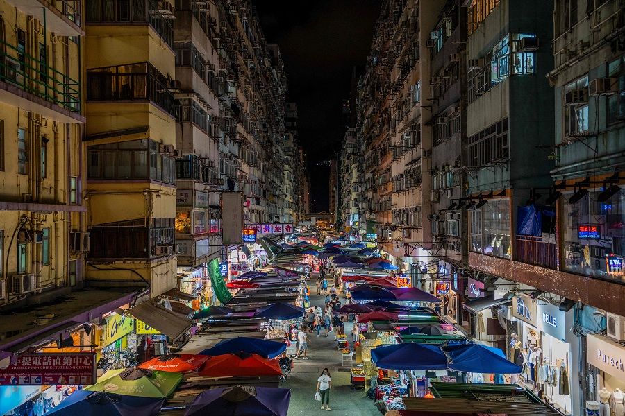 People walk at an outdoor market in Hong Kong's Mong Kok district on 20 August 2022. (Bertha Wang/AFP)