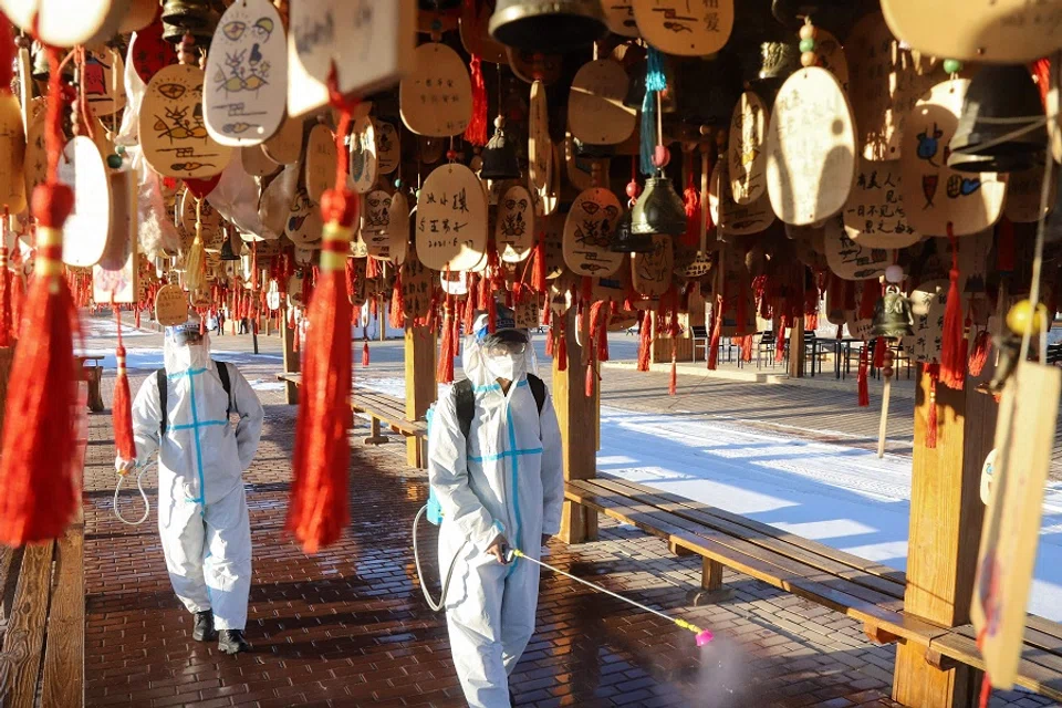 This photo taken on 15 November 2021 shows a staff member spraying disinfectant at the Zhangye Danxia Geopark in Zhangye, Gansu province, China. (AFP)