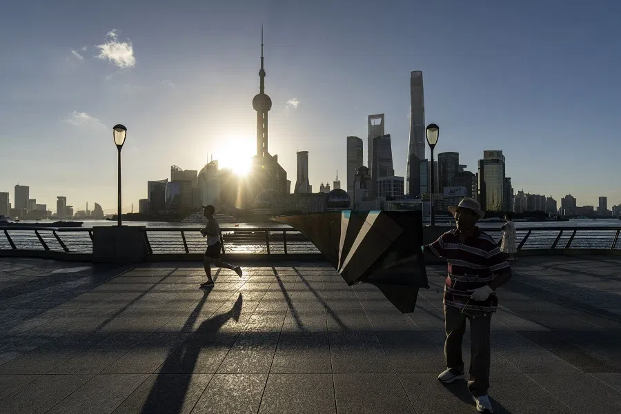 People walking along the Bund opposite commercial buildings in Pudong’s Lujiazui Financial District in Shanghai, China, on 13 September 2024.