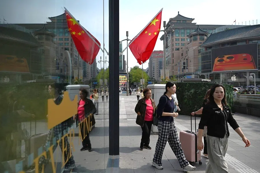 People walk outside a shopping mall in Beijing on 7 October 2025.
