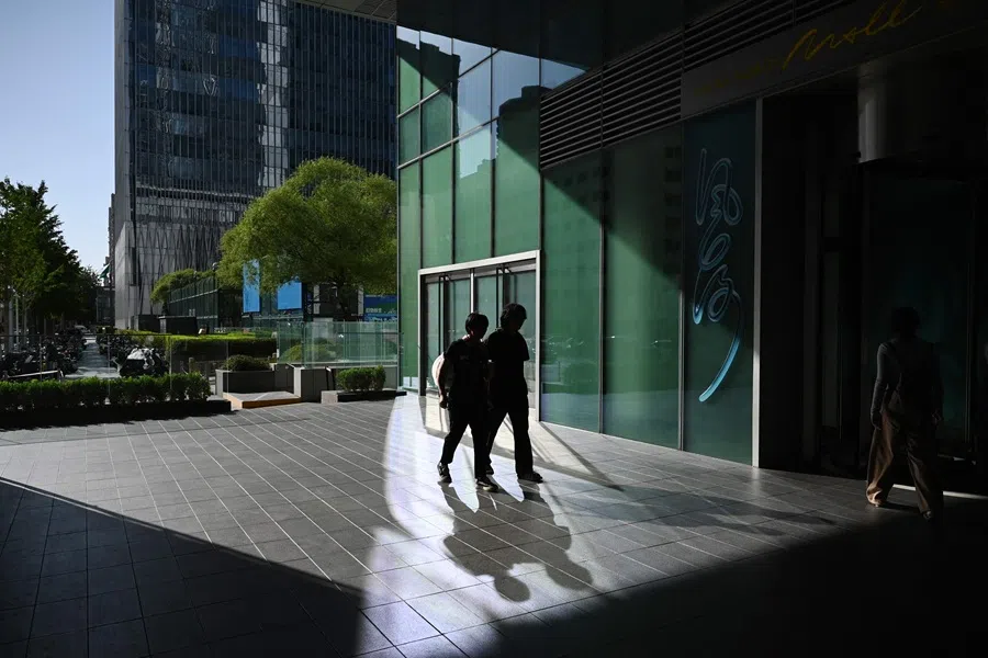 People walk outside a shopping mall in Beijing, China, 14 September 2025. (Greg Baker/AFP)