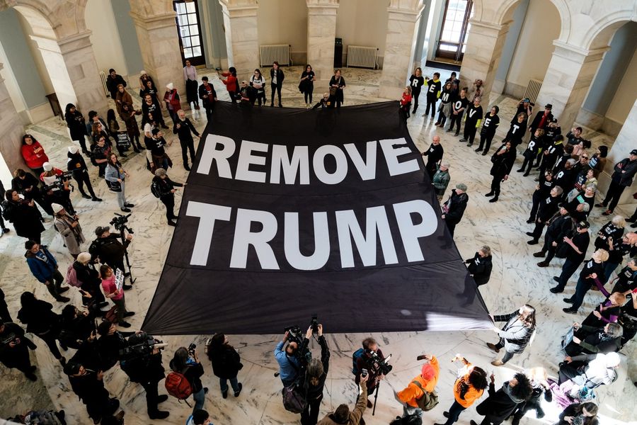 Protesters lay a banner calling for the removal of President Donald Trump inside the Russell Senate Office Building during a demonstration on 16 January 2020. (Michael A. McCoy/Reuters)