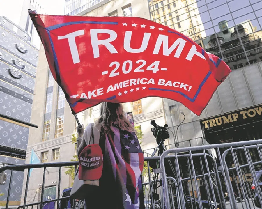 A person waves a Trump flag outside Trump Tower, after US President-elect Donald Trump won the presidential election, in New York City, US, on 6 November 2024.