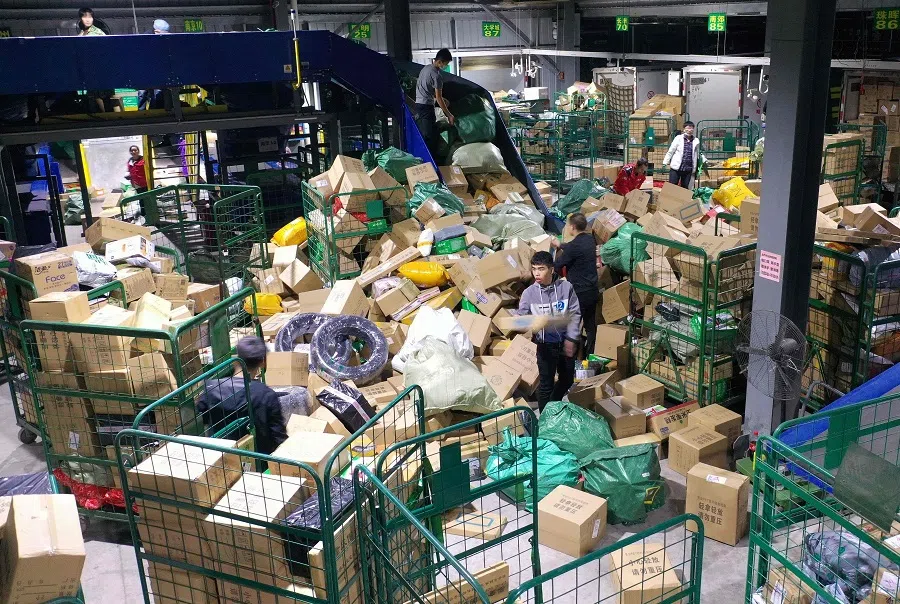 Workers sort packages for delivery at a warehouse of China Post Group in Hengyang, in China's Hunan province on 12 November 2020. (STR/AFP)