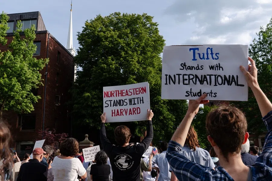 Demonstrators hold signs during a protest in support of international students at Harvard University in Cambridge, Massachusetts, US, on 27 May 2025. (Sophie Park/Bloomberg)
