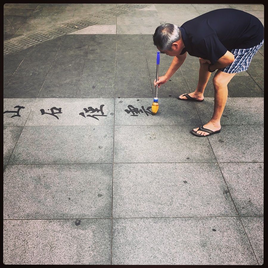 A retired man doing water calligraphy in Luxun park in Hongkou, Shanghai.