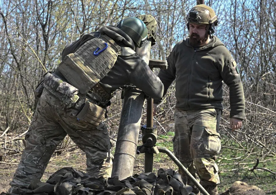 Belarusian volunteer soldiers from the Kastus Kalinouski regiment, a regiment made up of Belarusian opposition volunteers formed to defend Ukraine, aim a 120mm mortar at a front line position near Bakhmut in the Donetsk region, on 9 April 2023, amid the Russian invasion of Ukraine. (Genya Savilov/AFP)