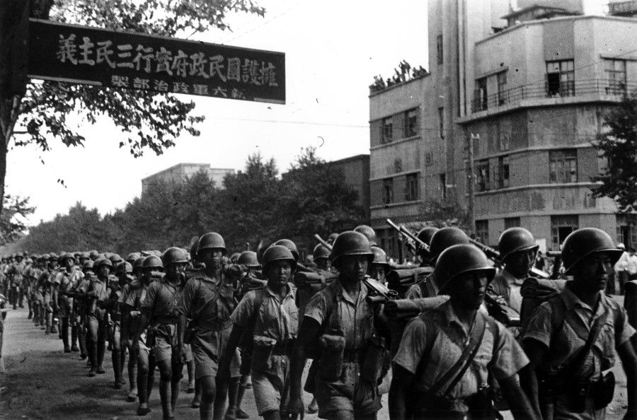 The New 6th Army walking the streets of Shenyang, April 1946. The sign shows a slogan coined by the political department of the New 6th Army: Support the Nationalist Government in Implementing the Three Principles of the People.