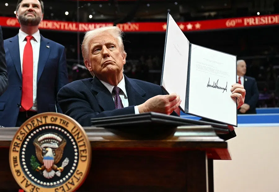 US President Donald Trump holds letter to the UN stating the US withdrawal from the Paris Agreement during the inaugural parade inside Capital One Arena, in Washington, DC, on 20 January 2025. (Jim Watson/AFP)