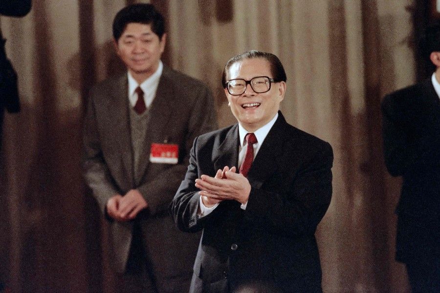 In this file photo taken on 19 October 1992, General Secretary of the Chinese Communist Party Jiang Zemin applauds in Beijing during a press unveiling to introduce new members to the standing committee of the poliburo. (Mike Fiala/AFP)