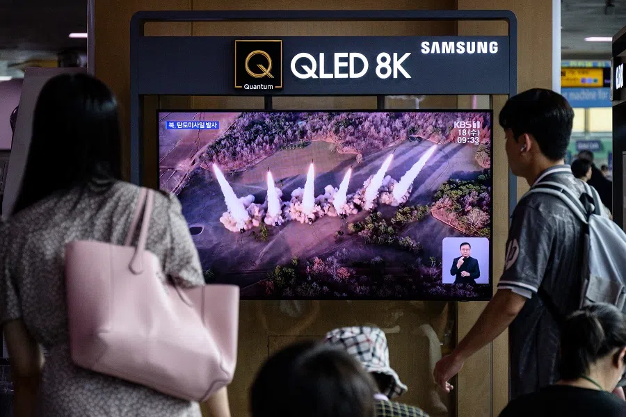 People watch a television screen showing a news broadcast with file footage of a North Korean missile test, at a train station in Seoul on 18 September 2024. (Anthony Wallace/AFP)