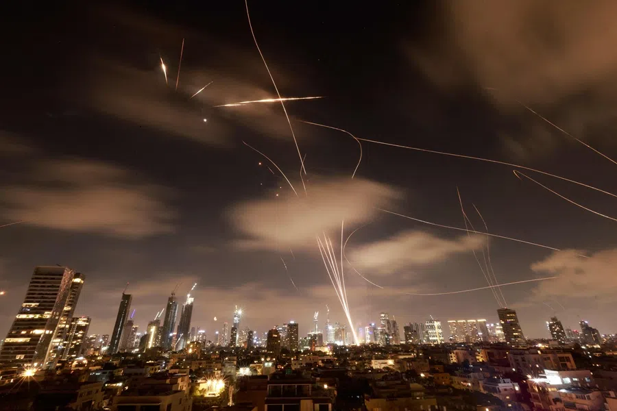 Israeli air defence systems are activated to intercept Iranian missiles over the Israeli city of Tel Aviv early on 18 June 2025. (Menahem Kahana/AFP)