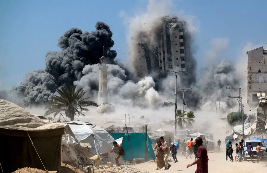 Palestinians run as the 15-story Mushtaha Tower collapses after being hit by an Israeli air strike, in Gaza City, on 5 September 2025.