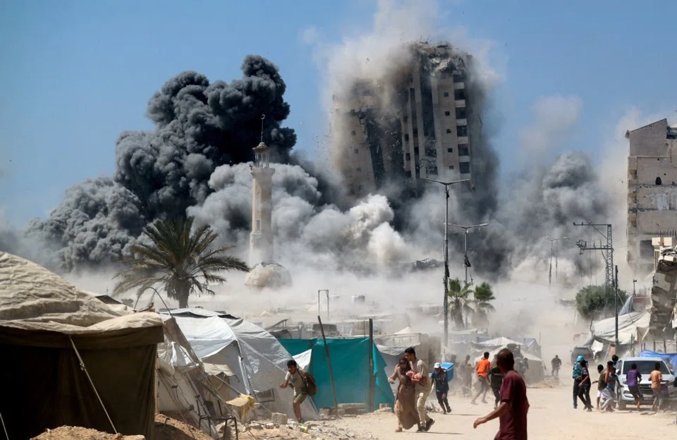 Palestinians run as the 15-story Mushtaha Tower collapses after being hit by an Israeli air strike, in Gaza City, on 5 September 2025. (Mahmoud Issa/Reuters)