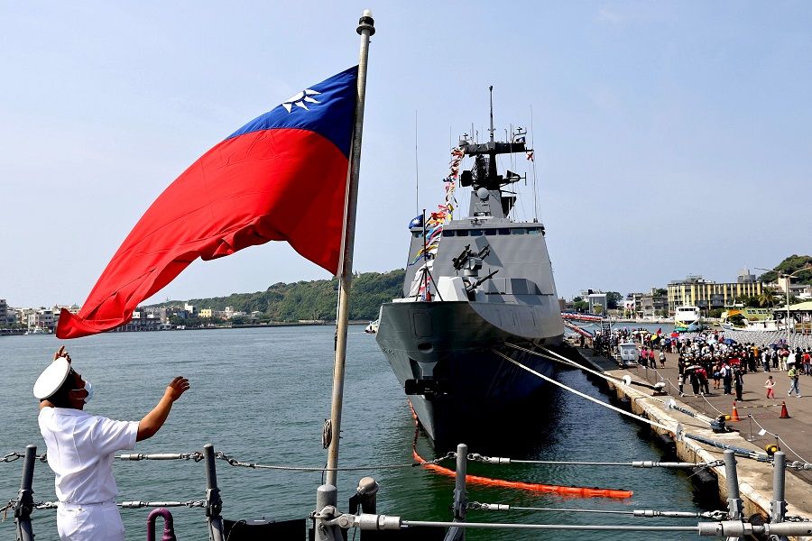 A navy soldier adjusts a Taiwan flag onboard ROCS Chang Chien (PFG2-1109) ahead of the Double Tenth Day celebration in Kaohsiung, Taiwan, 9 October 2021. (Ann Wang/Reuters)