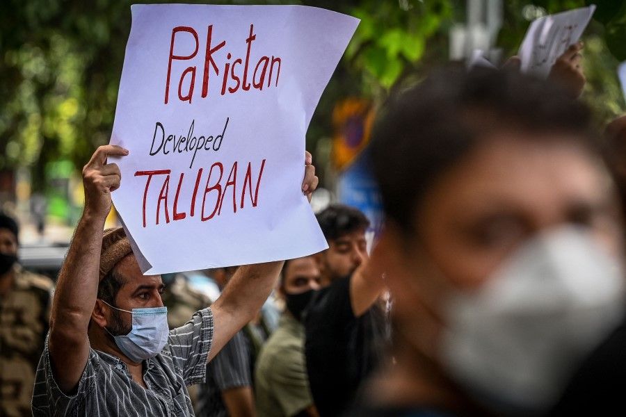 Afghan nationals residing in India hold banners and placards during a protest in New Delhi on 14 September 2021, against Pakistan's alleged support to the Taliban in Afghanistan. (Sajjad Hussain/AFP)