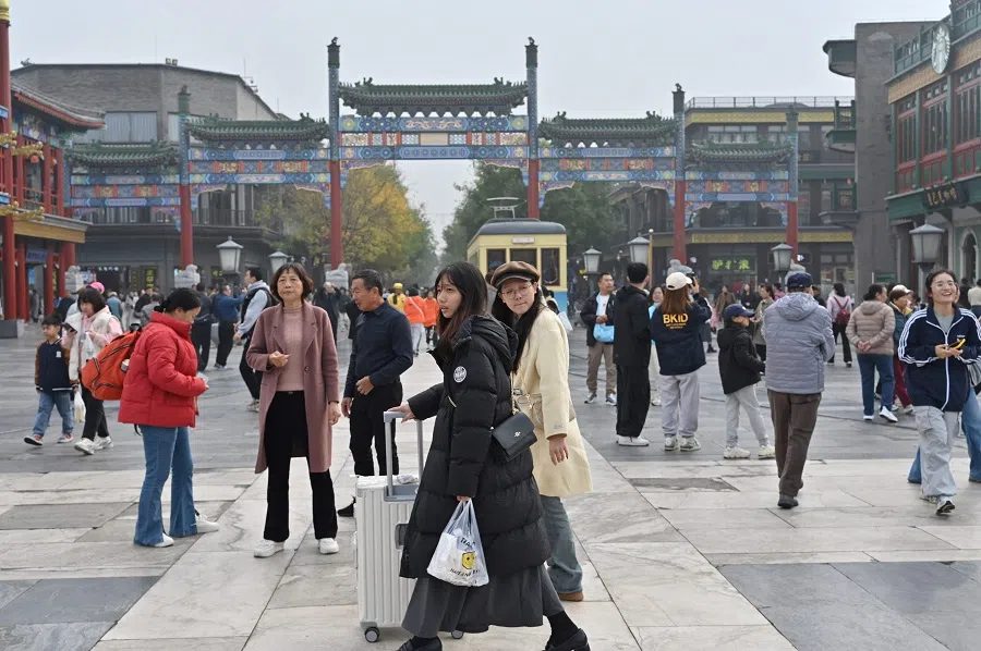People walk at the Qianmen street in Beijing on 2 November 2024.