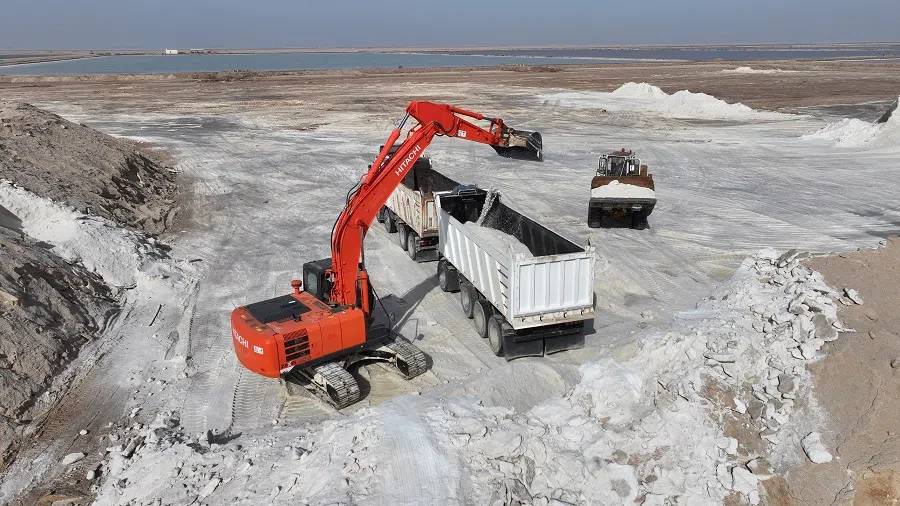 A drone view shows heavy machinery loading salt into trucks at a salt factory — a facility that uses seawater evaporation and benefits from Iraq’s extreme heat to boost salt production — in Basra, Iraq, on 15 May 2025. (Mohammed Aty/Reuters)