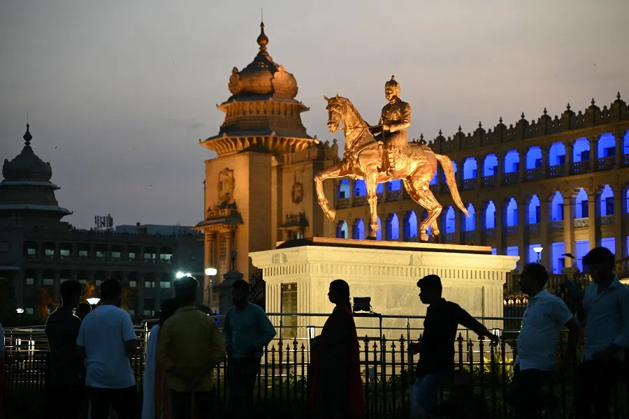 People visit Vidhana Soudha during sunset, in Bengaluru on 21 April 2024. (Idrees Mohammed/AFP)
