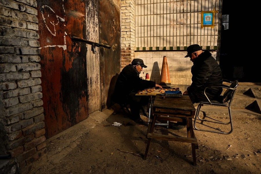 This photo taken on 7 January 2023 shows men playing a board game in a rural area in Tai'an, China's eastern Shandong province. (Noel Celis/AFP)