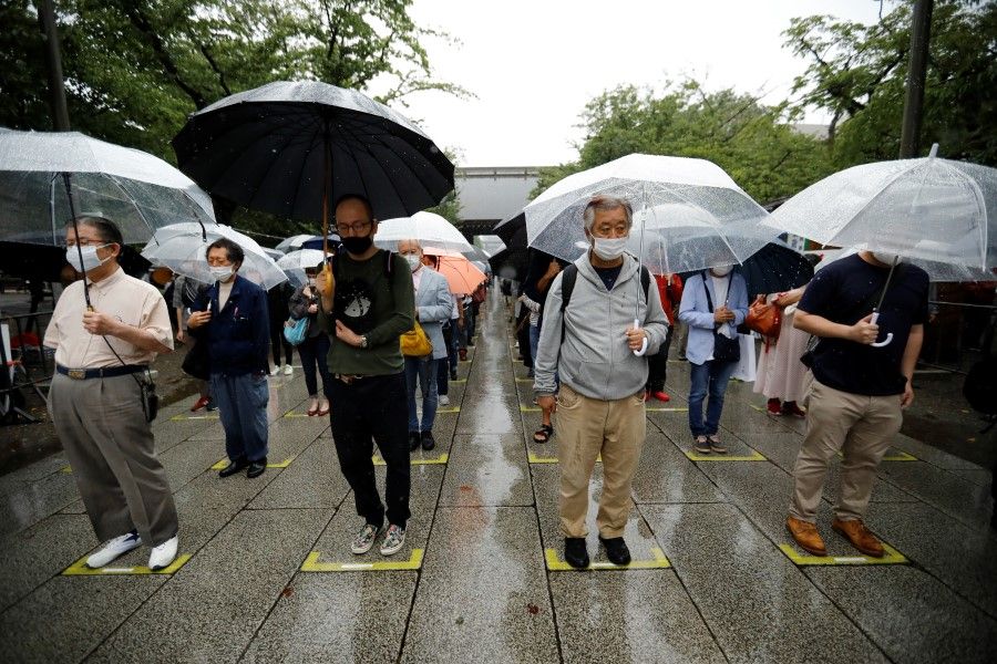 People pay silent tribute during their visit to Yasukuni Shrine on the 76th anniversary of Japan's surrender in World War Two, amid the coronavirus disease (Covid-19) pandemic, in Tokyo, Japan, 15 August 2021. (Issei Kato/Reuters)