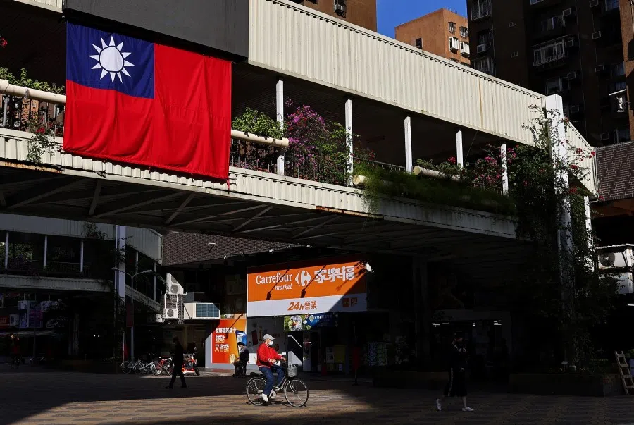 A man cycles past a Taiwan flag in Taipei, Taiwan, 16 November 2021. (Ann Wang/Reuters)