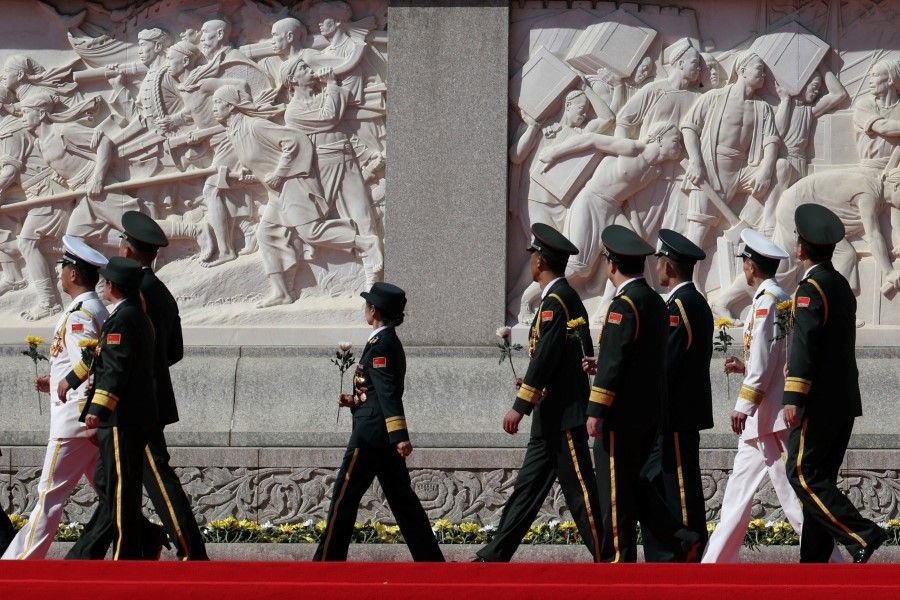 Members of the Chinese People's Liberation Army (PLA) attend a ceremony to present flowers at the Monument to the People's Heroes to commemorate Martyrs' Day, a day ahead of China's National Day, on Tiananmen Square in Beijing, China, 30 September 2023. (Florence Lo/Reuters)