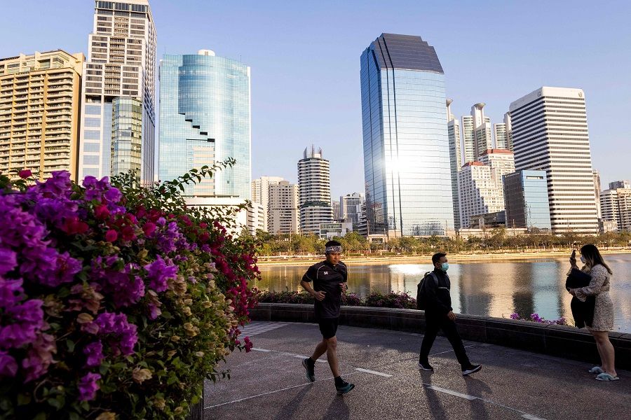 People jog and walk along a path in Benjakitti Park in Bangkok, Thailand, on 19 January 2022. (Jack Taylor/AFP)