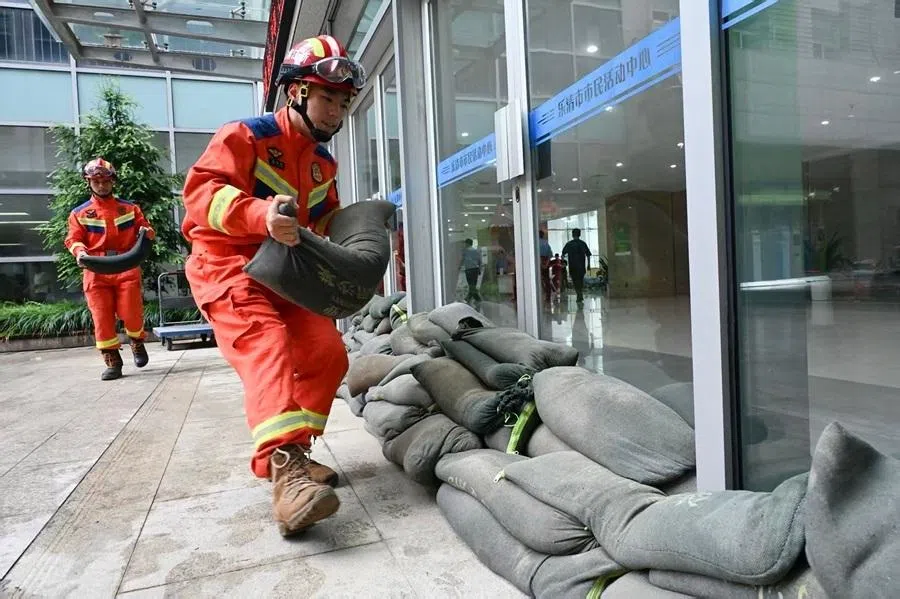 Firefighters place sand bags to reinforce windows and doors at an evacuation centre in Yueqing city in Wenzhou, China’s eastern Zhejiang province, on 11 July 2026, ahead of approaching Typhoon Bavi.