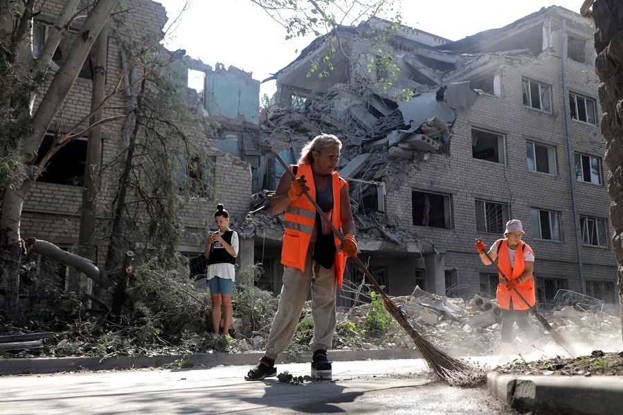 Communal workers clean outside a building destroyed as a result of Russian shelling in Mykolaiv, Ukraine, on 2 August 2022, amid Russia's invasion of Ukraine. (Oleksandr Gimanov/AFP)