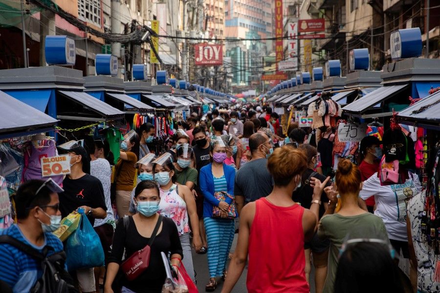Filipinos wearing masks and face shields for protection against the coronavirus disease (COVID-19) walk along a street market in Manila, Philippines, 3 December 2020. (Eloisa Lopez/REUTERS)