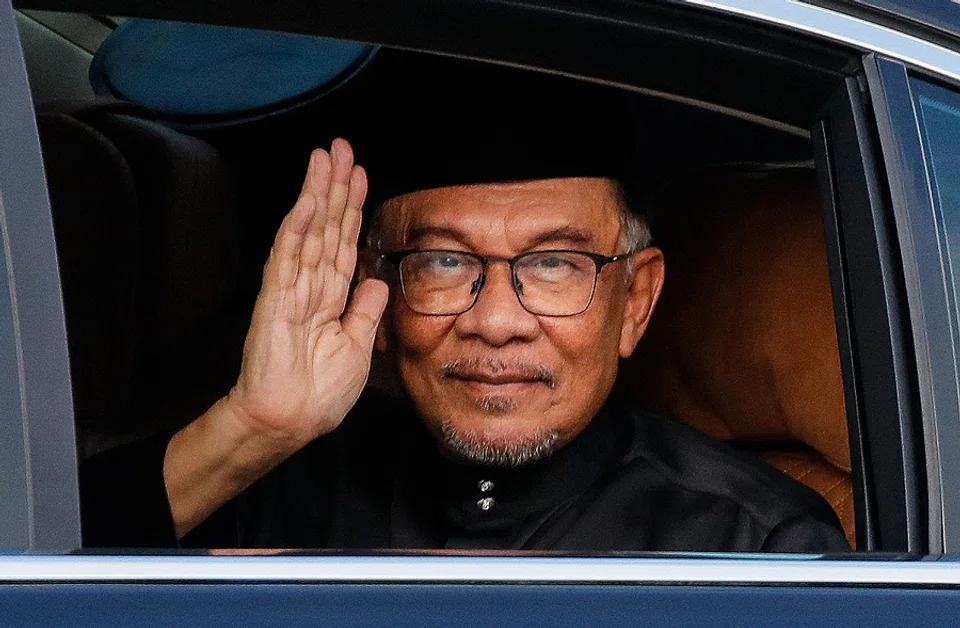 Malaysia's newly appointed Prime Minister Anwar Ibrahim waves from his car as he arrives to take part in the swearing-in ceremony at the National Palace in Kuala Lumpur, Malaysia, on 24 November 2022. (Fazry Ismail/Pool/AFP)