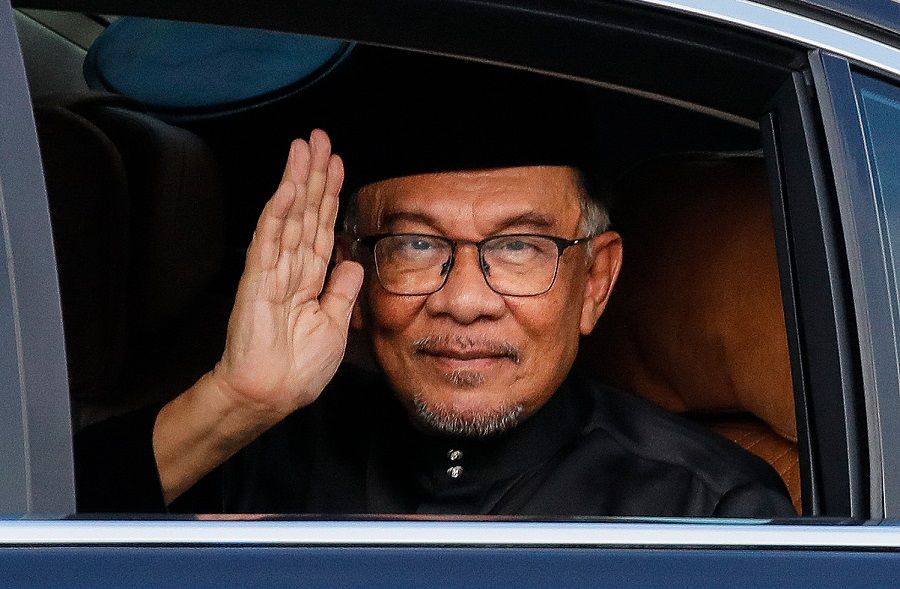 Malaysia's newly appointed Prime Minister Anwar Ibrahim waves from his car as he arrives to take part in the swearing-in ceremony at the National Palace in Kuala Lumpur, Malaysia, on 24 November 2022. (Fazry Ismail/Pool/AFP)